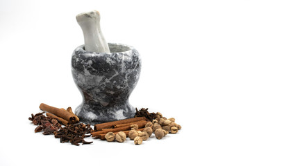 dried spices such as cardamom clove cinnamon and nutmeg placed around marble mortar with pestle, alternative drugs or nature medicinal concept