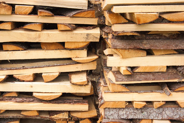 Wood for the village stove or fireplace stacked in a stack. Dry wood texture. Ecologically clean fuel. Selective focus.