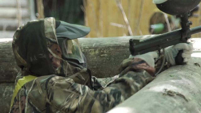 Children and teenagers play paintball. Close-up of the players during the game.