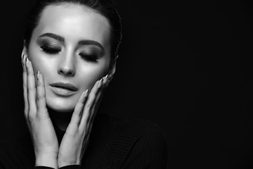 Beauty Cosmetics.Woman applying black mascara on eyelashes with makeup brush. photos of appealing brunette girl on black background.High Resolution