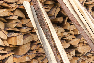 Wood for the village stove or fireplace stacked in a stack. Dry wood texture. Ecologically clean fuel. Selective focus.