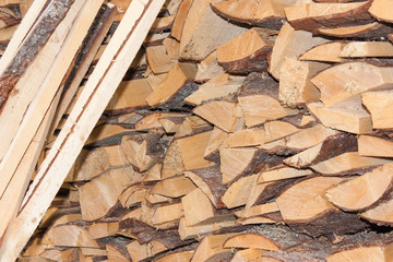 Wood for the village stove or fireplace stacked in a stack. Dry wood texture. Ecologically clean fuel. Selective focus.