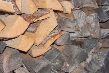 Wood for the village stove or fireplace stacked in a stack. Dry wood texture. Ecologically clean fuel. Selective focus.