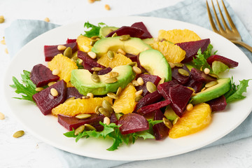 Vegan salad with beet curd avocado orange feta ricotta and pumpkin seeds, keto ketogenic dash diet, closeup, pastel modern background