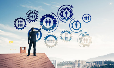 Businessman on house roof presenting teamwork and connection con