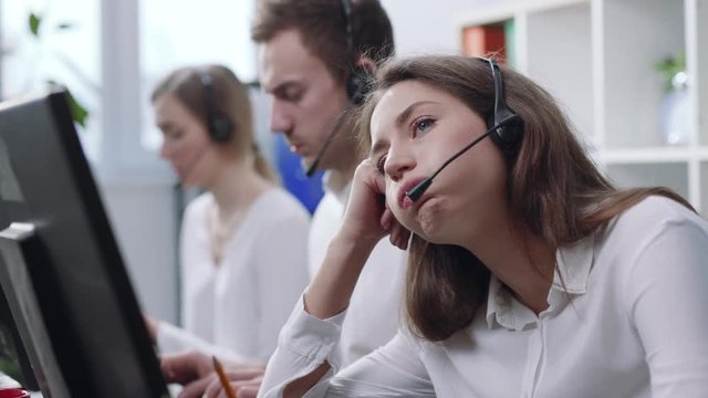 Depressed bored operator women of working call center services with headset at workplace. Call center and customer service help desk concept. Boring job and profession concept