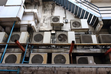 Group of condensing units of air conditioners installed on canopy behind the building, behind the scene concept