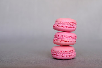 Stack of delicious french pink strawberry flavour macarons on grey background