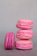 Obraz na płótnie Canvas Stack of delicious french pink fruity flavour macarons on grey background