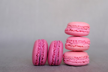 Stack of delicious french raspberry and blueberry flavour macarons on grey background