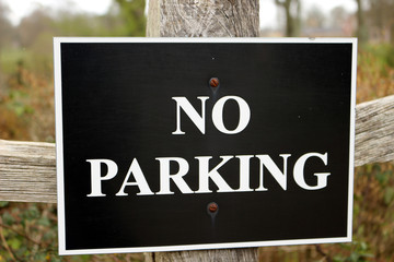 No Parking Sign on a Fence