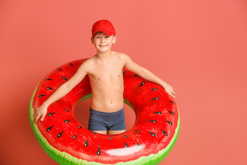 Cute little boy with inflatable ring on color background © Pixel-Shot