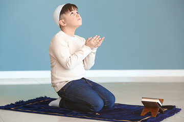 Little Muslim boy praying indoors