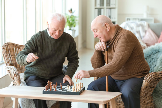 Senior men playing chess in nursing home