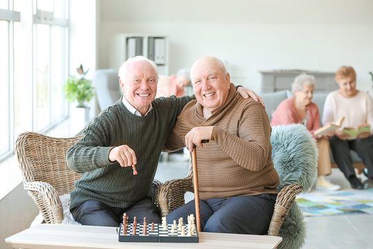 Senior Men Playing Chess In Nursing Home