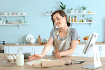 Beautiful young woman cooking pastry in kitchen