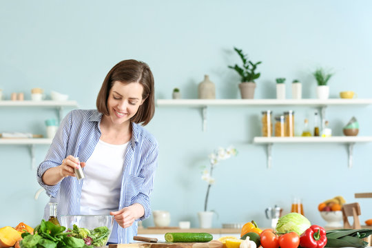 Young Woman Making Salad In Kitchen