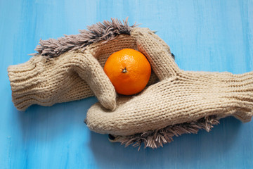 Christmas composition with bright mandarin and mittens, new year decor