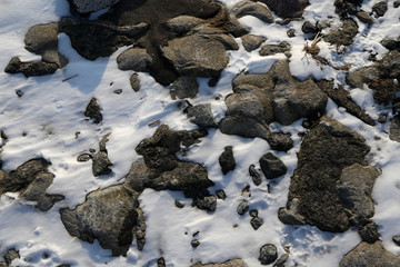 graue steine und schnee an der nordsee küste