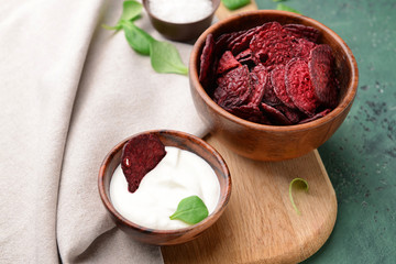 Tasty beet chips with sauce on table