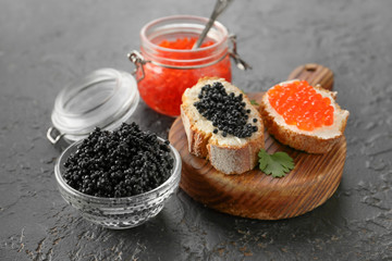 Sandwiches with delicious caviar on dark background