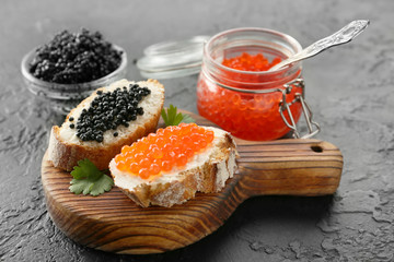 Sandwiches with delicious caviar on dark background - obrazy, fototapety, plakaty
