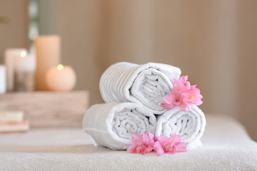 Fototapeta na wymiar Rolled towels on massage table in spa salon
