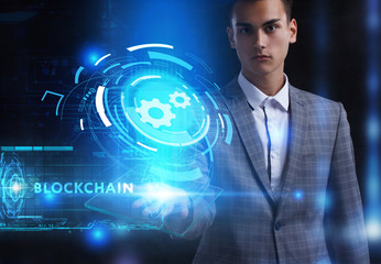 The concept of business, technology, the Internet and the network. A young entrepreneur working on a virtual screen of the future and sees the inscription: Blockchain