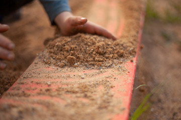 The child is playing in the sand. School Montessori sensory education. Hyperactive baby. The hands of a child.