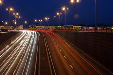 Fototapeta premium Road at night in St. Petersburg, moving cars and trails of their luminous headlights