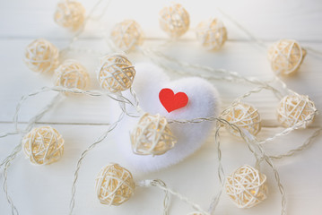Red and white hearts on wooden background. Saint Valentine's day concept. Love and romantic photo. Postcard for holiday. Small rustic lights.