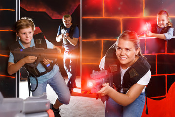 satisfied teen boy having fun on laser tag arena with his older