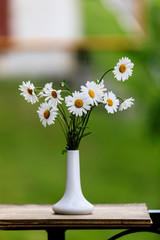 bouquet of flowers in vase on a green background