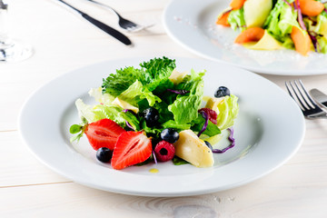 Fresh Blueberries, Cranberry salad with arugula, nuts, feta cheese, olive oil, herbs. Morning, breakfast healthy food.