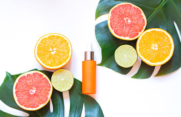 Cosmetic flat lay with vitamin C serum and citrus on the white background. Top view 