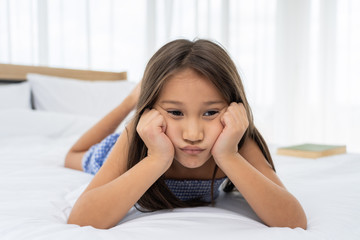 Asian girl on a white bed are sad and unhappy.