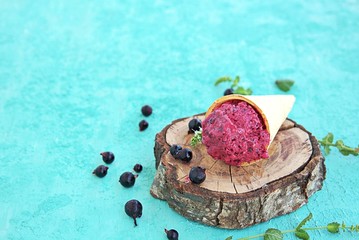 Dessert, frozen yogurt with black currant, in a waffle cone. Summer desserts concept. Copy space.
