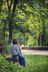 Sweet twin brothers, children sitting on bench in park