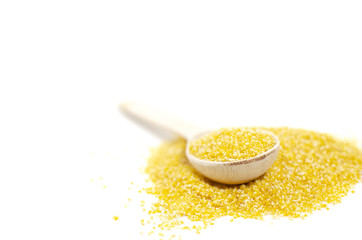 Bright corn grits with a wooden spoon are on a white background