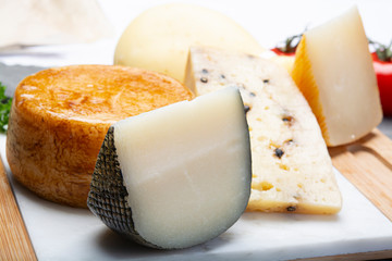 Variety of Italian pecorino cheeses, yellow aged, with black peppers from Nebrodi, white Il Palio and black molarotto, close up