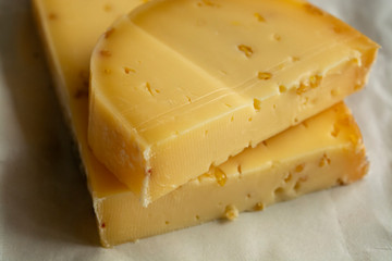 Piece of cow cheese with fenugreek seeds made in Belgian abbey by monks.