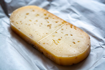 Piece of cow cheese with fenugreek seeds made in Belgian abbey by monks.