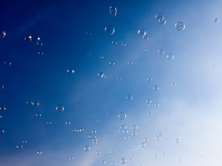Soap bubbles fly in the blue sky