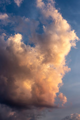 Fototapeta na wymiar Einzelne Wolke am Abendhimmel von der Sonne angestrahlt 1 Hochformat