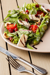 Tasty and healthy salad with arugula, brie, cheese, avocado, cherry tomatoes, dry cranberry and cashews. Top view. The flat lay. Banner