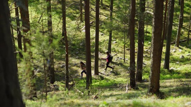 High Angle View Of Group Of Scared Four Backpackers Running Through Forest In Fear, Lockdown Shot