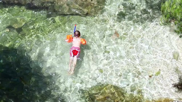 Little boy snuckering in the warm Adriatic sea waves