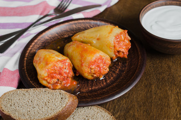 Stuffed peppers with rice and minced meat stew in tomatoes, rye bread. Rustic food.