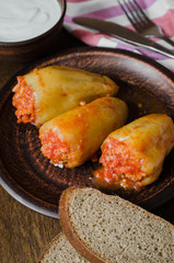 Stuffed peppers with rice and minced meat stew in tomatoes, rye bread. Rustic food.
