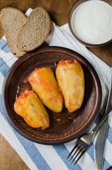 Stuffed peppers with rice and minced meat stew in tomatoes, rye bread. Rustic food.